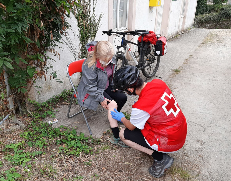 Técnicos y voluntarios de Cruz Roja prestando asistencia sanitaria a una peregrina